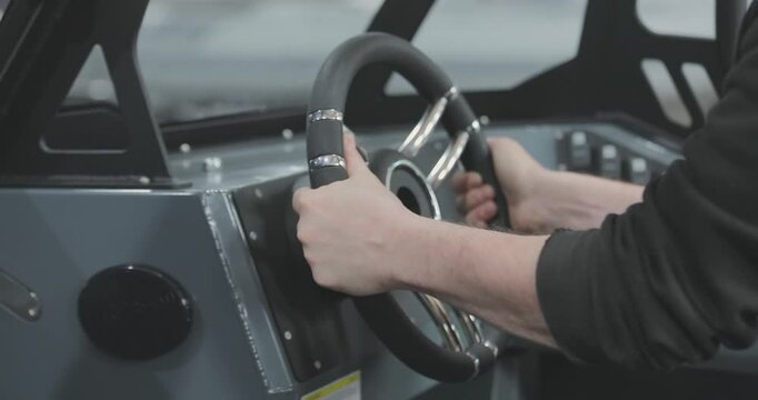 A factory for the production and assembly of modern motorboats and yachts. Assembly of the steering system of a motorboat. Close-up of a worker installing the steering wheel on a motorboat. Wheelhouse