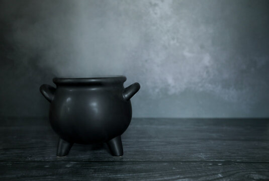 Smokey cauldron on dark spooky backdrop with copy space