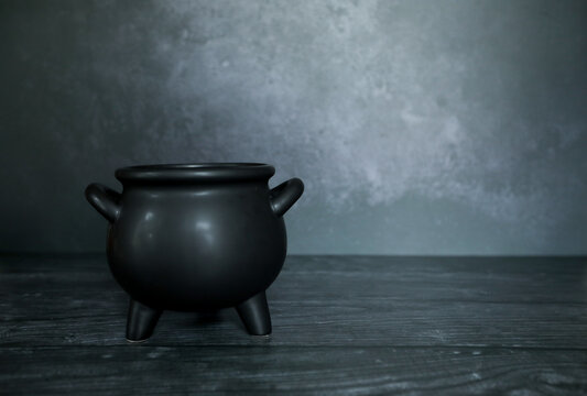Witches cauldron on dark spooky backdrop with copy space