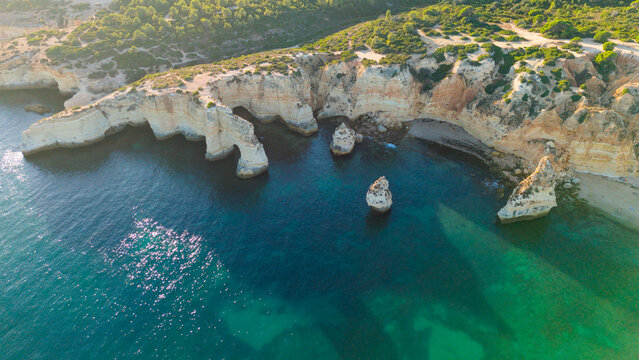 Aerial view of rocky coastal formations above turquoise sea in Portugal. Algarve. Beach 