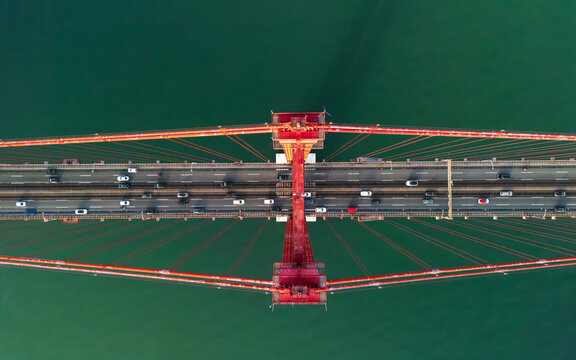 Aerial view of the 25 de Abril Bridge with traffic flowing across the red suspension structure over the Tagus River in Lisbon, Lisbon, Portugal.