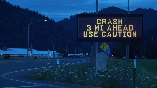OREGON - 9.2.2026 - Close-up of a "caution crash ahead" road sign by an Oregon mountain at dusk.