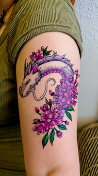 A person with a tattoo of a dragon and flowers on their arm
