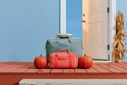 Navy travel duffel and small suitcase resting on a weathered porch between ribbed pumpkins, with a foil pie on top for homecoming and travel ads
