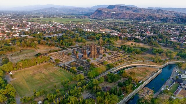 Aerial view of Prambanan Temple complex surrounded by lush green trees and historic ruins in the rural landscape of Kecamatan Prambanan, Daerah Istimewa Yogya, Indonesia.