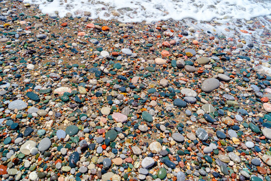 Colorful pebbles on beach with small waves washing ashore in Kattavia, Rhodes, Greece