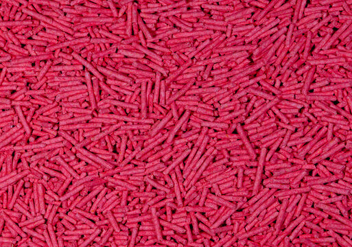 Red Tofu Cat Litter Pellets Background. Abstract Pattern of Textured Red Rods. Full Frame Pile of Crimson Tofu Litter