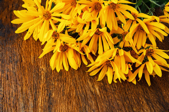 Yellow autumn wild sunflowers bouquet on rustic wooden background with copy space