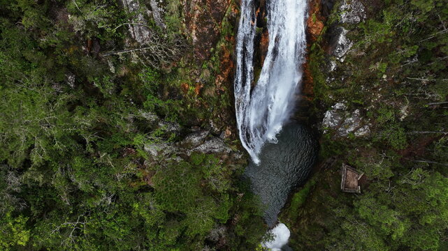 Aerial view of Salto de Aguas Blancas waterfall cascading into a lush green forest pool in Constanza, La Vega Province, Dominican Republic.