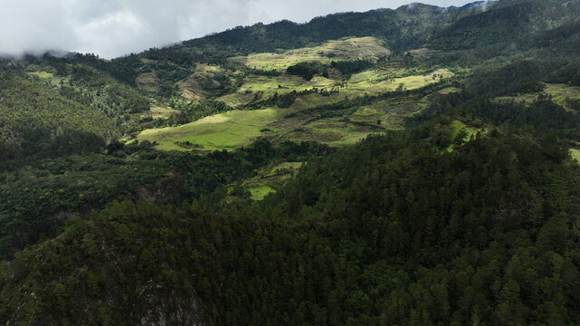 Aerial view of the mountainous landscape near the Carretera al Salto de Aguas Blancas, featuring pine forests, rolling hills, and agricultural fields in Constanza, La Vega, Dominican Republic.
