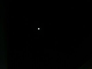 Bright full moon glowing brilliantly in the dark midnight sky with clear starlight conditions © Aizaz