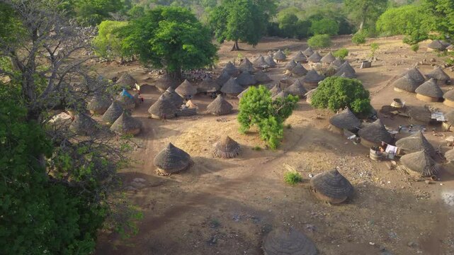 SENEGAL - 7.24.2026 - Wonderful aerial footage of people walking around thatched dwellings in a Bedik village of Senegal.
