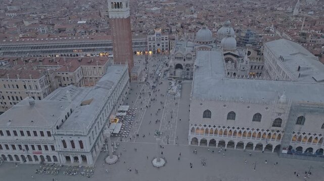 Aerial view of St. Mark's Square featuring the Campanile, St. Mark's Basilica, and the Doge's Palace with people walking in Venice, Veneto, Italy.
