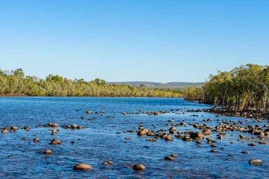 Scenic Penticost River rock edges and flowing water under blue sky