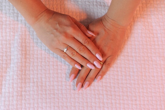 mulher com unha rosa feita por manicure 