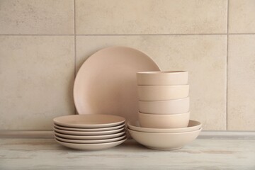 Clean tableware on light wooden countertop in kitchen