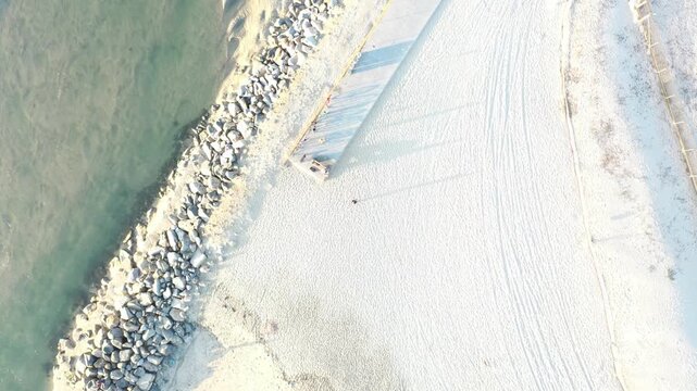Overhead aerial of rocky shoreline and sandy beach in Huntington Beach