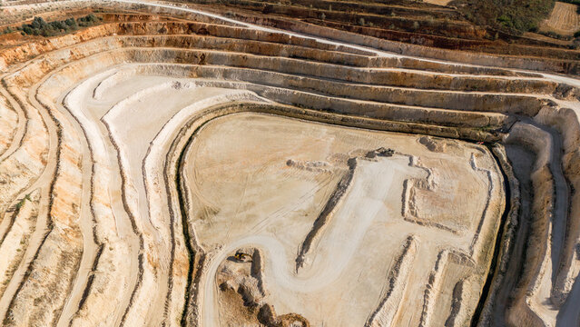 Aerial view of the open-pit limestone quarry with terraced excavation levels and industrial earthworks in Besenovo, Vojvodina, Serbia.