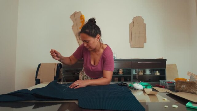 Skilled Woman Hand-Stitching Fabric for Custom Clothing Design at Home Studio