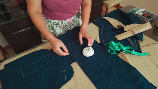 Woman Pins Fabric for a Sewing Project, Demonstrating Craftsmanship and Creative Hobby.