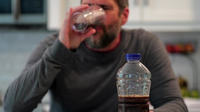 Middle aged man drinking prune juice to aide digestive health naturally - gut health constipation relief remedy aging gracefully preventive wellness