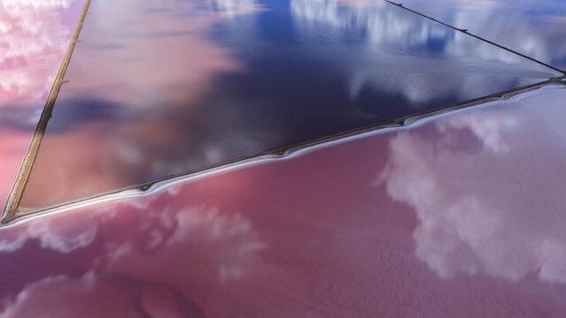 Aerial view of vibrant pink and deep blue salt production ponds with reflective water surfaces and geometric dikes in Kalbarri, Western Australia, Australia.