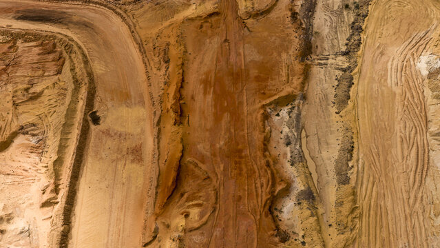Aerial view of industrial mining patterns showing textured sand, salt deposits, and earth formations in a remote landscape in Kalbarri, Western Australia, Australia.