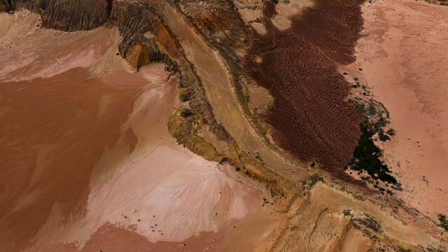 Aerial view of the salt lakes and industrial patterns near Useless Loop, showcasing vibrant mineral deposits, textured sand, and earth tones in Kalbarri, Western Australia, Australia.