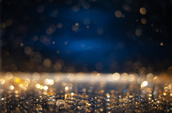 Macro photo of golden glitter particles on neon blue background