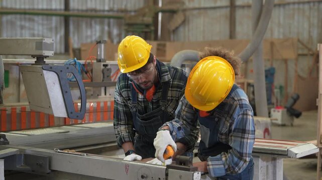 Workers build wooden structures in a workshop while focusing on their tasks and using various tools for their project