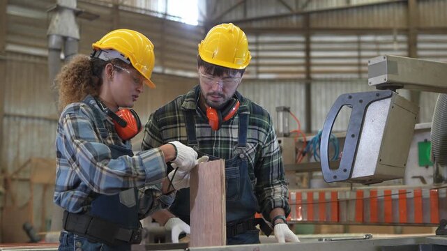 Workers use tools in a workshop to complete a project with safety gear and teamwork