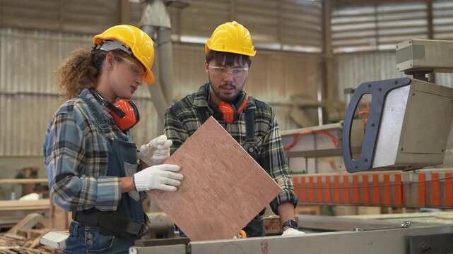 Workers cut wood in a workshop with safety gear and machinery to make wooden products