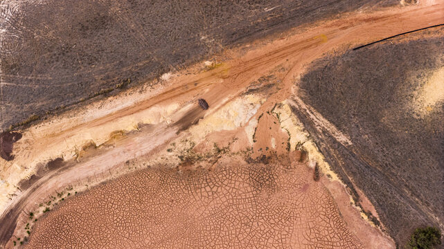 Aerial view of industrial salt patterns and textured terrain with brown and yellow sand deposits near Useless Loop in Kalbarri, Western Australia, Australia.