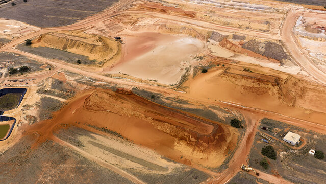 Aerial view of industrial sand and salt extraction patterns with brown and yellow earth textures near Kalbarri, Western Australia, Australia.