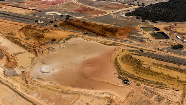 Aerial view of industrial salt mining patterns and sand dunes at Useless Loop, showing vibrant brown and yellow earth tones after a storm in Kalbarri, Western Australia, Australia.