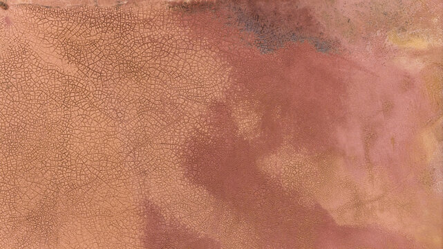 Aerial view of the salt lake patterns in Western Australia, showing cracked earth textures in shades of pink, brown, and yellow after a storm, Kalbarri, Western Australia, Australia.