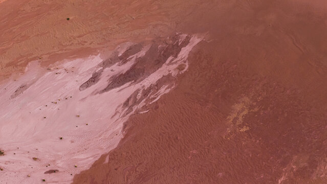 Aerial view of the vibrant pink salt lakes and industrial patterns at Useless Loop, showing contrasting textures of sand and salt deposits in Kalbarri, Western Australia, Australia.