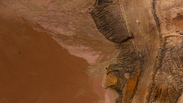 Aerial view of industrial salt mining patterns with sand and earth in brown and yellow tones after a storm near Useless Loop in Kalbarri, Western Australia, Australia.