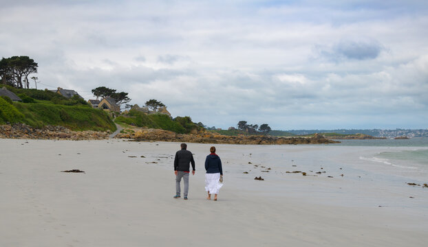 Un couple qui se prom&egrave;ne sur une plage en Bretagne