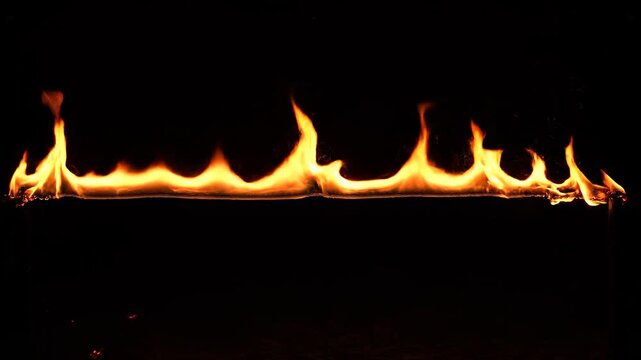 Dynamic fire line burning with intensity against a dark background representing energy and danger