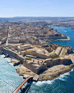 Aerial view of Fort Saint Elmo and the historic city of Valletta, featuring limestone fortifications, dense urban rooftops, and the sea in Valletta, Port Region, Malta.