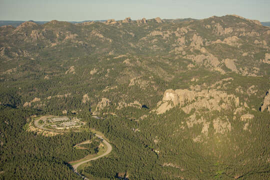 Aerial view of Mount Rushmore National Memorial surrounded by the rugged Black Hills landscape and pine forests in Keystone, South Dakota, United States.