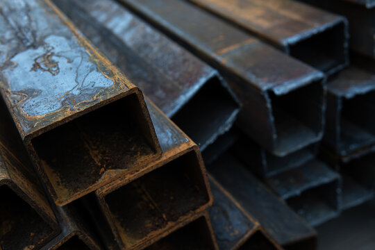 Rusty square steel pipes in warehouse