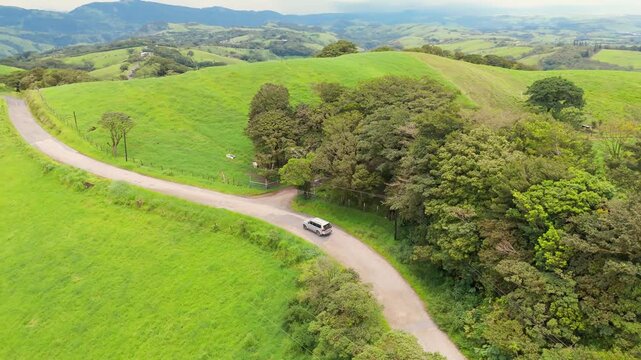 Aerial view of a car driving on a countryside road