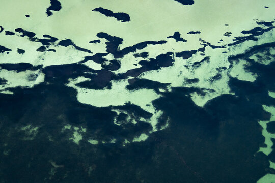 Aerial view of intricate ocean patterns with turquoise shallows and deep blue channels in the Shire of Shark Bay, Western Australia, Australia.