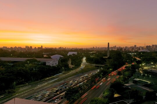 Vista panor&acirc;mica do Parque Ibirapuera e tr&aacute;fego na Avenida 23 de Maio durante o p&ocirc;r do sol em S&atilde;o Paulo, Brasil