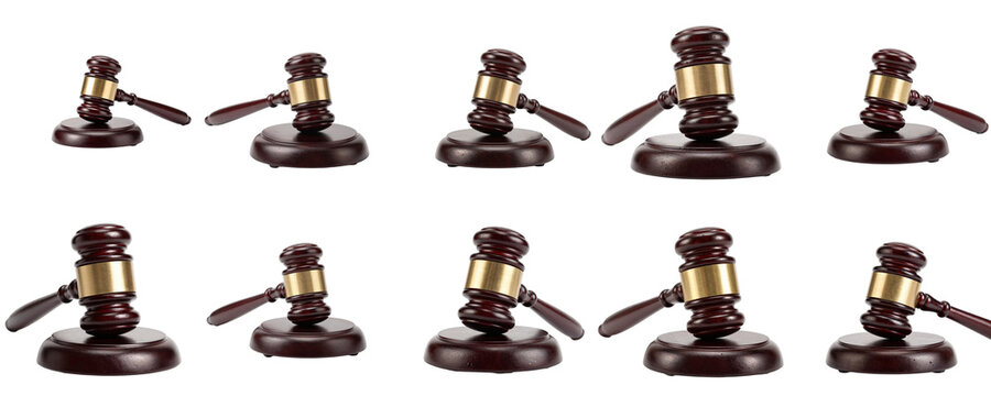 Wooden judge gavel with brass fitting pattern against a black backdrop