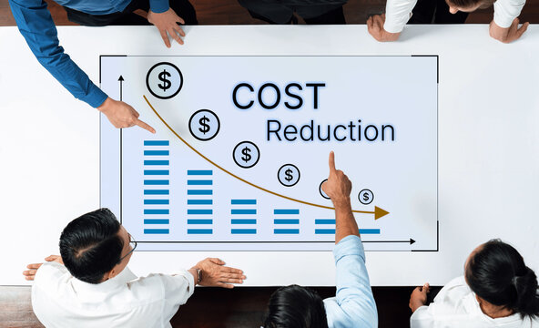 Business Team Analyzing Cost Reduction Strategies with Graph and Dollar Signs to Highlight Financial Efficiency on Office Table. Bitwise.