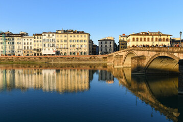 Fototapeta premium Scenic view of Ponte alla Carraia bridge over Arno River with historic buildings reflection, Florence, Tuscany, Italy