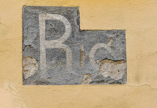 World War II air raid shelter wall sign with engraved letters R I for Ricovero, Florence, Tuscany, Italy